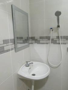 a white bathroom with a sink and a shower at 15 Homestay in George Town