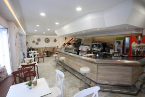 a restaurant with a counter and tables and chairs at Hotel Cervantes in Alicante