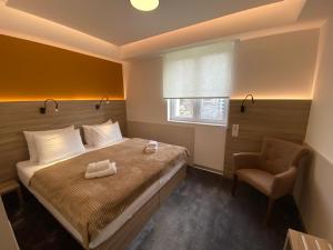 um quarto com uma cama e uma cadeira em Konak Stella em Belgrado