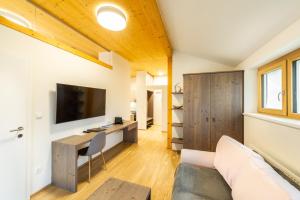 a living room with a couch and a desk with a television at Apartmenthaus Pastner am Teich in Übelbach