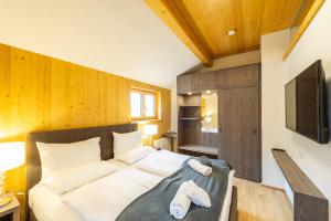 a bedroom with a large bed and a television at Apartmenthaus Pastner am Teich in Übelbach