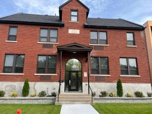a red brick house with a black door at Cozy Maison Apt #3 in Gatineau