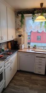 une cuisine avec des placards blancs et une fenêtre dans l'établissement Villa Svalan, à Hällefors