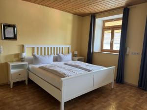 1 dormitorio con cama blanca y ventana en Zum Zacherwirt, en Hengersberg