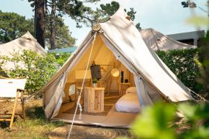 a teepee tent with a bed in it at Kampaoh Bayona Playa in Baiona