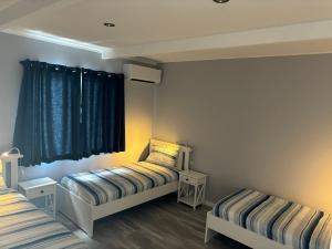a bedroom with two beds and a window at Kalbarri Sunset Villa in Kalbarri