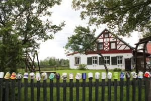 a fence with lots of hats on it in front of a house at Penzion Na Gruntu in Lipná