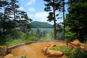 a swimming pool with a view of a lake at Urabandai Lake Resort Goshiki no Mori in Kitashiobara