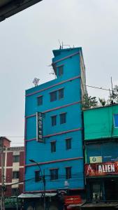 un bâtiment bleu sur le côté d'une rue dans l'établissement Hotel Padma Residential Jatrabari, à Dhaka