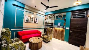 sala de estar con sofá rojo y sillas en Pearl by ven a casa-Home Stays, en Jaipur