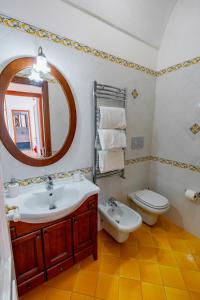 a bathroom with a sink and a toilet and a mirror at Ferriere Apartment in Scala