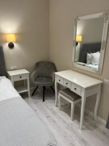 a bedroom with a desk and a mirror and a chair at Vila Niki in Sovata