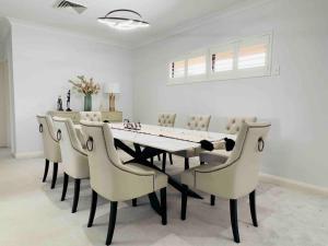a dining room with a table and chairs at Maroubra Gem Close to Everything Sleep 16 in Sydney
