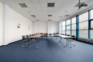 a large room with tables and chairs and windows at Karpackie Pokoje in Krosno