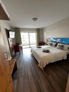 ein Schlafzimmer mit einem großen Bett und einem großen Fenster in der Unterkunft Apartments Urlaub im Chiemgau in Aschau im Chiemgau