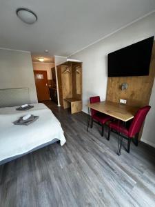 um quarto de hotel com uma cama e uma mesa e uma televisão em Apartments Urlaub im Chiemgau em Aschau im Chiemgau
