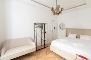 um quarto branco com uma cama e uma cadeira em Paris Eiffel em Paris
