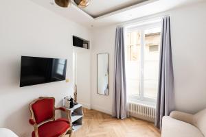 - un salon avec une chaise rouge et une fenêtre dans l'établissement Paris Eiffel, à Paris