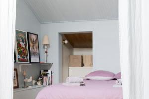 een witte slaapkamer met een bed met roze lakens bij Appartement rénové avec goût et idéalement situé à deux pas du remblai in Les Sables-dʼOlonne