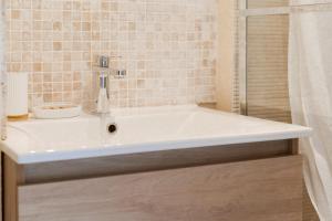 Un baño con lavabo blanco y ducha. en Appartement rénové avec goût et idéalement situé à deux pas du remblai, en Les Sables-dʼOlonne