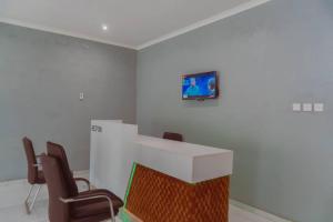 Pokój z krzesłami i blatem z telewizorem na ścianie w obiekcie Adams lodges Ltd w mieście Mangochi