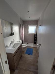 baño con lavabo y aseo y ventana en Casa di Maritz 10b, en Palafolls