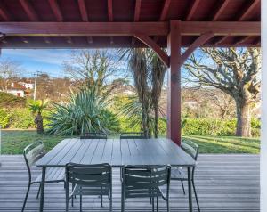 a wooden table and chairs on a deck at La Senpere - Maison à 20min de Saint Jean de Luz in Saint-Pée-sur-Nivelle