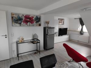 - un salon avec un réfrigérateur et une chaise rouge dans l'établissement Home sweet home in Ludwigsburg, à Ludwigsbourg