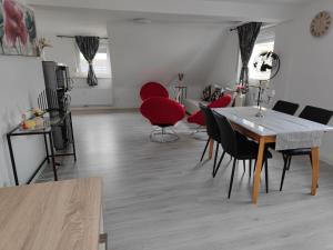 uma sala de estar com uma mesa e cadeiras vermelhas em Home sweet home in Ludwigsburg em Ludwigsburg