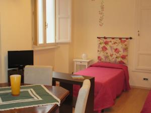 uma sala de estar com uma cama e uma mesa com uma sala de jantar em Mimì Apartment em Lucca