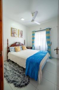 um quarto com uma cama com um cobertor azul em Zayn Cozy homes em Mombasa