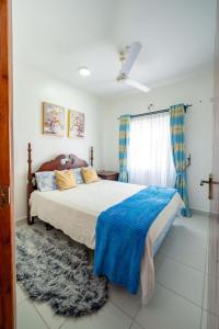 um quarto com uma cama grande e um cobertor azul em Zayn Cozy homes em Mombasa