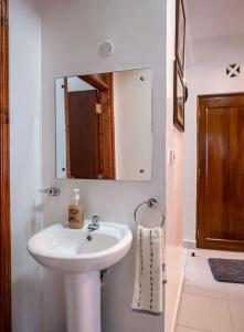 Un baño con un lavabo blanco y un espejo. en Zayn Cozy homes, en Mombasa