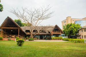 een gebouw met een rieten dak in een park bij Bomah Hotel Limited in Gulu