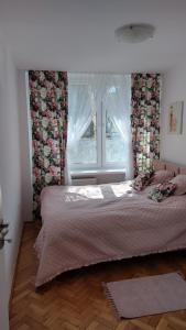 a bedroom with a large bed with a window at Apartament Marszałkowska in Warsaw