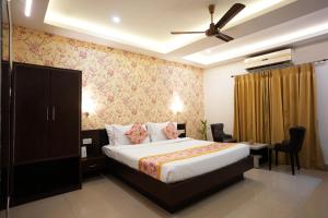 a hotel room with a bed and a ceiling fan at Voyage Comfort Primer Inn in Siliguri