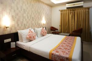 una camera d'albergo con un grande letto con cuscini di Voyage Comfort Primer Inn a Siliguri