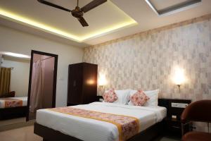 a bedroom with a large bed with a ceiling fan at Voyage Comfort Primer Inn in Siliguri