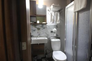 Galata By Boss Hotel في إسطنبول: حمام به مرحاض أبيض ومغسلة