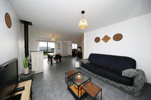 a living room with a couch and a table at L'Océraline - Maison avec jardin et wifi in La Lucerne-dʼOutremer
