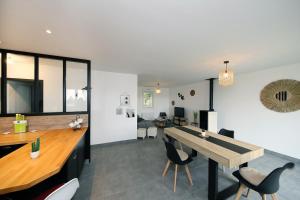 a dining room and living room with a table and chairs at L'Océraline - Maison avec jardin et wifi in La Lucerne-dʼOutremer