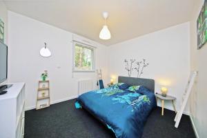 a bedroom with a blue bed and a window at L'Océraline - Maison avec jardin et wifi in La Lucerne-dʼOutremer
