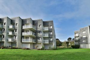 un immeuble d'appartements avec une pelouse devant lui dans l'établissement Cocon en bord de mer - Appt vue mer, à Saint-Cast-le-Guildo