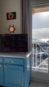 a blue cabinet in front of a window with a view at Apartment Hirondelle Port Frejus in Fréjus