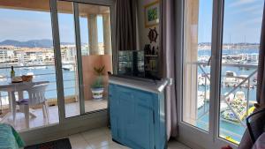 a room with a balcony with a view of a marina at Apartment Hirondelle Port Frejus in Fréjus