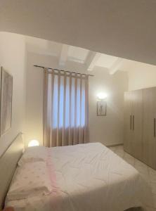 een slaapkamer met een groot bed en een raam bij LA CASA TRA GLI ULIVI in Spello