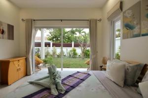 a bedroom with a bed with a large window at Villa Nokyoong in Hua Hin