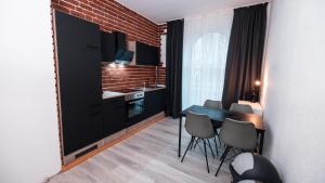 a kitchen with black cabinets and a table and chairs at Monteurwohnung in Freren Lingen in Freren