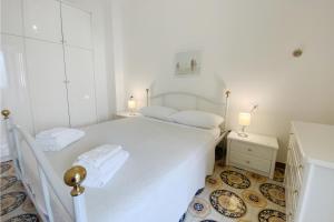 a white bedroom with a white bed with towels on it at La casa di Mariedda in Dorgali