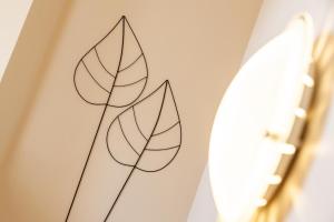 a drawing of leaves on a wall next to a surfboard at Seehaus Winkler in Weissensee